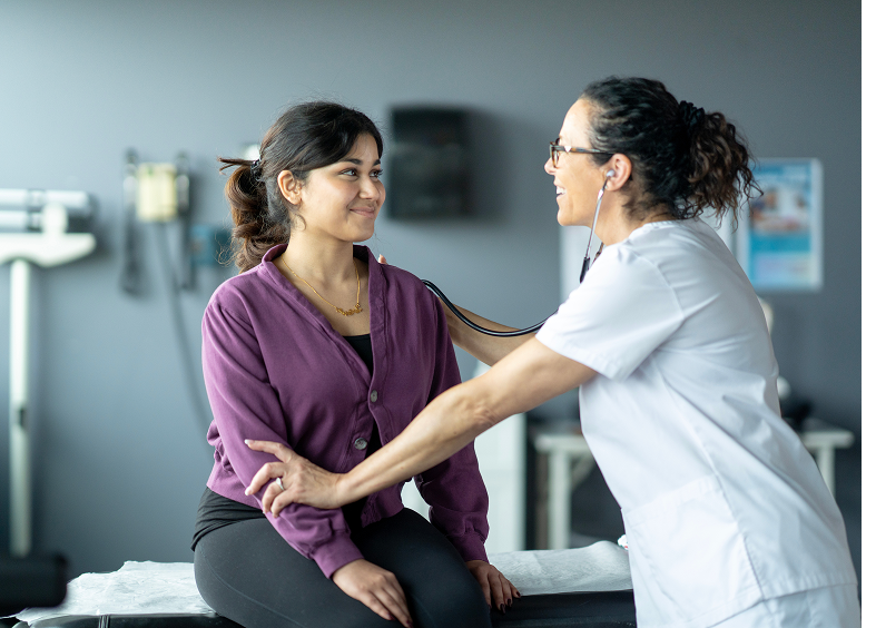 Doctor listens to patient's heartbeat with stethoscope.