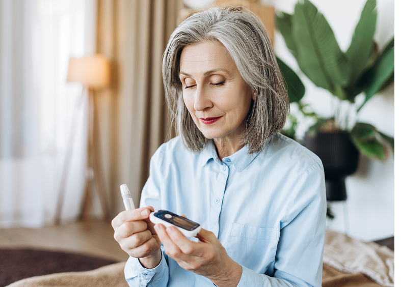 Mature woman monitoring glucose levels indoors