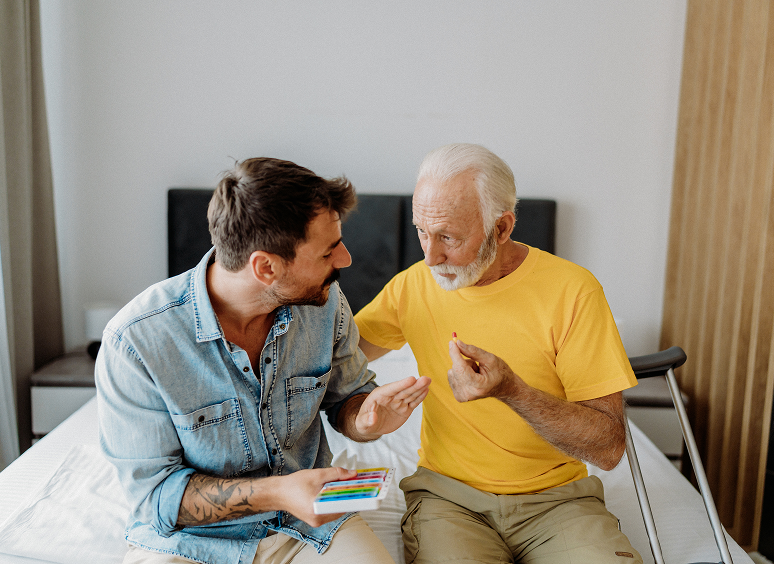 Man showing cards to older gentleman