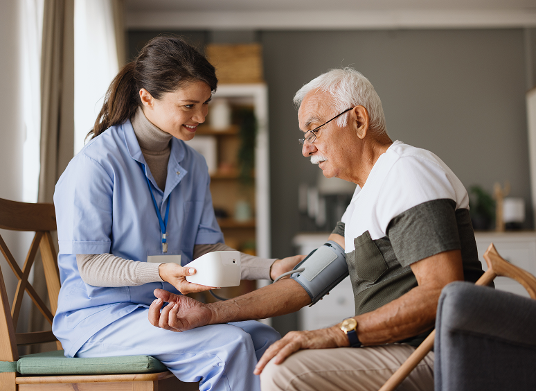 Nurse checking elderly man's blood pressure