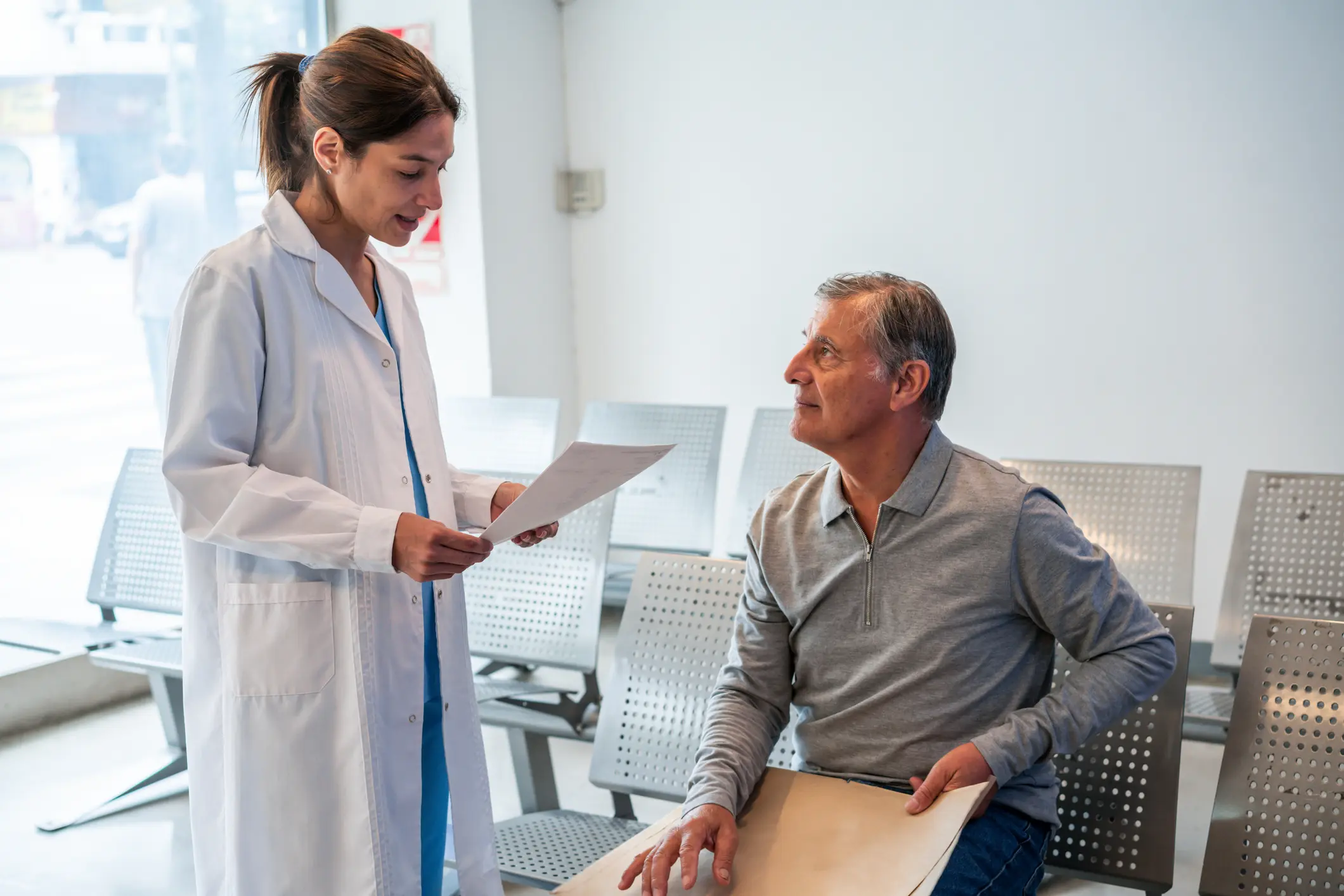 Healthcare professional consulting with seated man